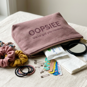 Oopsiee Everyday Emergency Kit with everyday emergency essentials in a dusty mauve pouch.